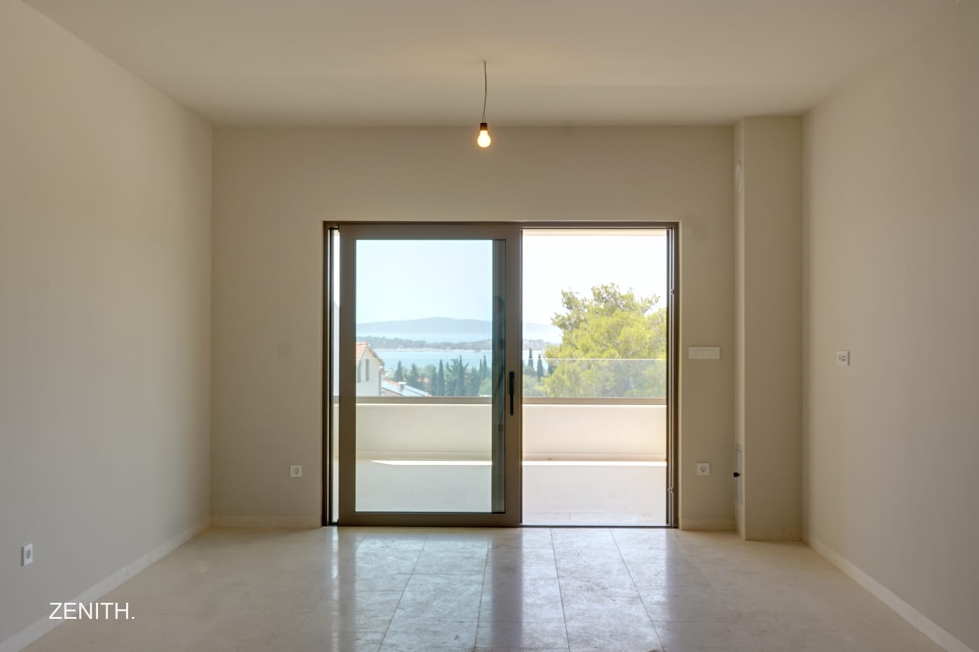 Wohnraum mit bodentiefer Verglasung und Blick auf das Meer