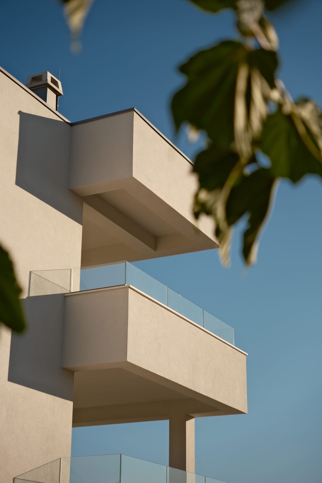 Auskragende Balkone vor blauem Himmel